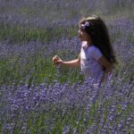 HM 8.0 This image brings a smile. The angle of the lavender being slightly to the right gives a sense of motion and the delightful expression on the girl's face tells a story of fun.