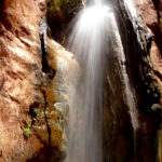 2nd - 3.0 - What a lovely veil of water you captured! And as what I see as thefocus of your image, nicely placed in the frame. Both the top of thewaterfall and the river below are blown out, drawing my eye to thosehot-spots rather than the waterfall. Probably a neutral density filterwould allow the slower shutter speed for the waterfall and not blow-out the top and river. Also, some targeted post-processing can pulldown those over-exposed areas. Capturing the image earlier or later inthe day may have helped, as well. A different f-stop may haveeliminated the soft focus on the rocks along the edges of the frame. I think this well-composed image just needs a little tweaking to be top-rate.