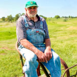 2nd - 8.0 - Puzzling expression. The overall setting including the equipment the man is sitting on brings a bit of mystery and uncertainness to the viewer which increases appeal. I would recommend lowering the saturation of the green color and crop about one third of the space from the left side to the man to better position the main subject. If possible, leaving more space above the man's head would enhance the composition. Darkening just a bit of the overall legs hot spots would also help the image a little.