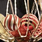 5.8 - The photo has an interesting arrangement of ornaments, and the basket provides a unifying element to the composition. The bright lighting and highlights make the image jump off the screen. But the overexposed ornament on the right edge and the too bright strands at the top are overpowering and lead the viewer’s eye right out of the frame. Also, the chains in the upper right are a bit out of place and distracting.