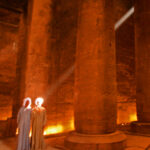 7.0 - Great use of a "God ray". The overall composition is good however the two persons head areas are blown out, especially the one on the right. I would recommend also lightening the ray segment between the column and the person to continue the brightness from the upper right segment of the ray. I like how the softness of the image provides an overall dreamy effect.